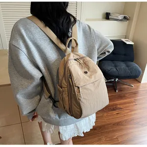 Vue arrière d'un mannequin portant un sac à dos en nylon kaki clair avec plusieurs poches