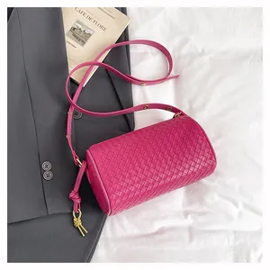 Detail of fuchsia woven pillow bag with fine leather texture and golden buckles