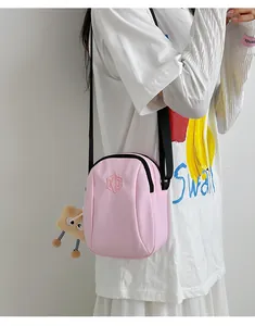 Dettaglio borsa a conchiglia in nylon rosa con tracolla e ciondolo toast in peluche