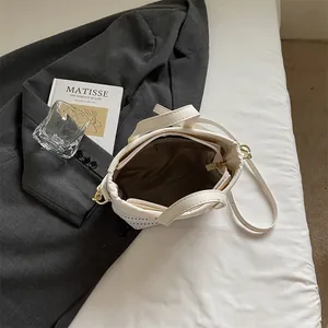 Minimalistische beige gewebte Tragetasche mit Reißverschlussfach auf grauem Blazer