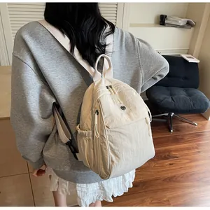 Détail d'un sac à dos minimaliste en nylon blanc crème avec poche latérale et bretelles