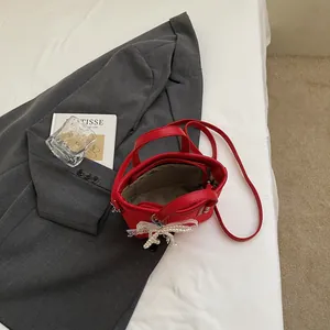 Red leather bucket handbag for women with lace bow charm and adjustable shoulder strap