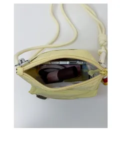 Top view of yellow nylon crossbody bag showing interior space for phone and makeup