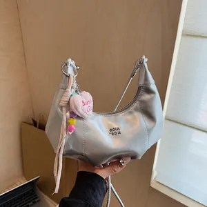 Silberne Halbmondtasche mit Metallic-Effekt und trendigen Y2K Barbie-Herzanhängern