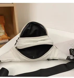 Internal compartments of a white nylon waist bag with black zippers and mesh lining