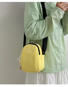 Dettaglio di una borsa a tracolla giallo brillante in nylon con cinturino nero