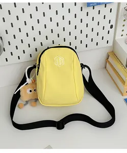 Dettaglio della borsa a tracolla in nylon giallo con tracolla regolabile e ciondolo toast