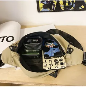 Detailoverzicht van kaki nylon borsttas interieur met ruimte voor telefoon en ritsen