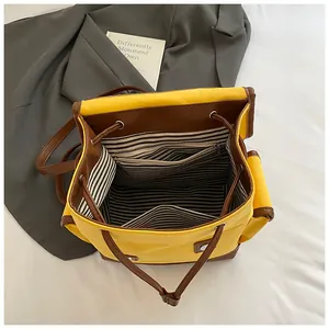 Detail view of contrast canvas backpack with drawstring closure and striped fabric lining