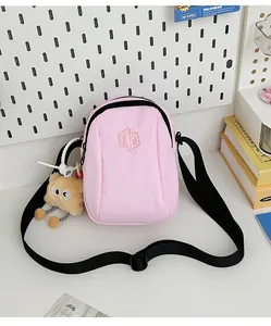 Dettaglio borsa a tracolla in nylon rosa con ricamo esagonale e ciondolo a forma di toast