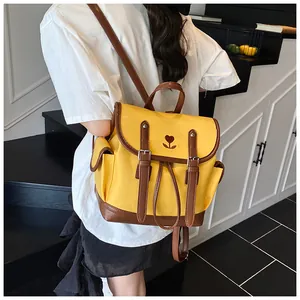 Detail of yellow contrast backpack with heart tulip embroidery and brown leather straps