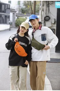 Outdoor lifestyle shot showing orange and olive green nylon waist bags with multi-pockets