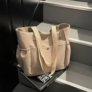 Large beige canvas tote bag with multi-pocket design for daily commuting and casual use