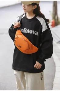 Close-up of vibrant orange nylon chest bag with double zipper and adjustable black strap