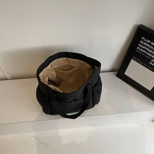Large black canvas tote bag for commute featuring multiple pockets and durable handles