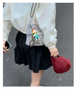 Detail of gray nylon bucket bag with ChicCraze label and colorful character pendant
