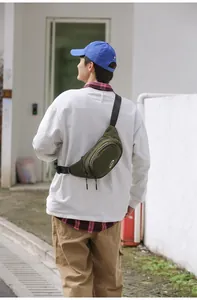 Detail showing the dark green sports crossbody bag with adjustable strap and logo