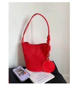 Detail of red suede bucket bag with knotted handle and matching round coin purse charm