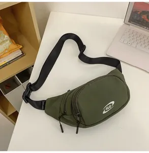 Detail of army green nylon waist bag featuring dual zippers and adjustable black strap