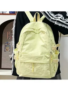 Detail of light yellow backpack with multiple pockets and side buckle straps for students