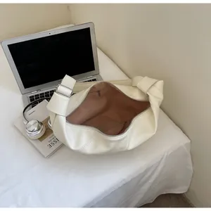 Détail du sac bandoulière blanc crème montrant la poche intérieure et le nœud décoratif