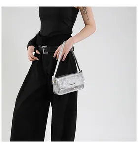 Detailed view of silver crocodile texture underarm bag with sleek metallic finish