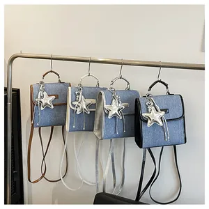 Detail view of denim texture backpacks with star charms and long tassels in four colors