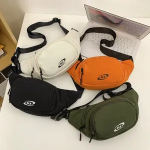 Nylon sport waist bags in four colors with adjustable branded straps on a desk