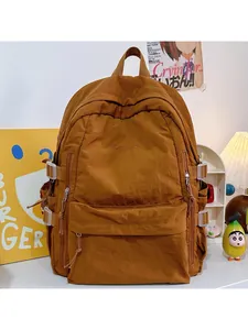 Detail of a large brown school backpack with multiple zippers and KBYLLD embroidery