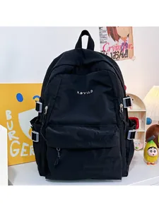 Detail of black nylon backpack featuring white logo embroidery and side adjustable buckles