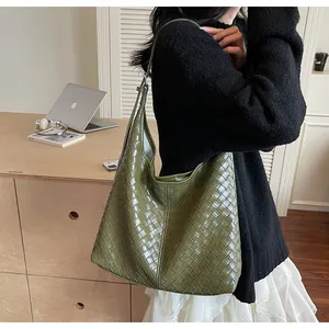 Dettaglio della borsa tote intrecciata verde oliva con trama in pelle pregiata e stile hobo