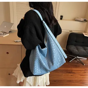 Dettaglio della borsa tote intrecciata azzurra con grande capacità e pelle morbida