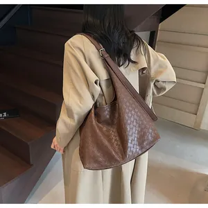 Dettaglio della trama in pelle intrecciata marrone caramello e tracolla regolabile borsa