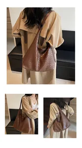 Dettaglio della trama in pelle intrecciata marrone scuro di una borsa hobo
