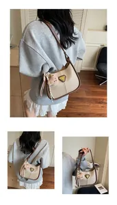 Vue détaillée du sac hobo en cuir beige avec liseré marron et charm ours mignon