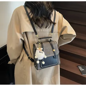 Detailed back view of a grey fashion backpack featuring a cute white teddy bear charm