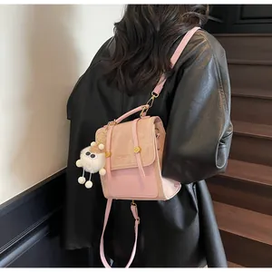 Pink leather versatile backpack with plush charm worn by model in a stylish leather jacket