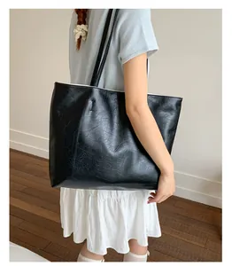 Grand sac cabas vintage noir en cuir ciré porté par un mannequin pour le travail