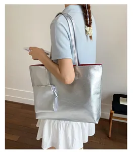 Détail du cabas plissé argenté avec doublure rouge et pochette zippée assortie