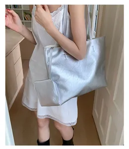 Détail du sac cabas plissé argenté avec une pochette zippée assortie au style épuré