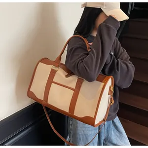 Close-up of canvas travel bag with leather straps and metal buckle details on the side