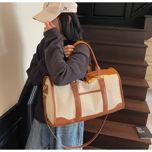 Detail view of canvas travel bag with brown leather trim and sturdy adjustable shoulder strap