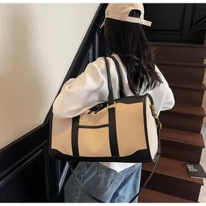 Rear view of a model carrying the canvas travel bag with leather trim on stairs