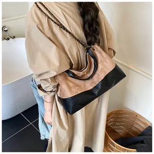 Détail du sac seau hobo en cuir noir matelassé et suède beige avec texture contrastée