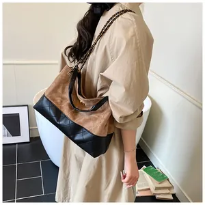 Détail du sac seau contrasté montrant les coutures en daim et le cuir matelassé