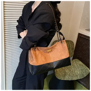 Détail du sac seau bicolore avec surpiqûres en losanges et fermoir rotatif doré