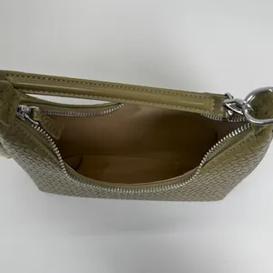 Top view of olive green woven leather shoulder bag showing zipper and interior capacity