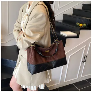 Détails de surpiqûres matelassées et bandoulière chaîne dorée du sac cabas bicolore