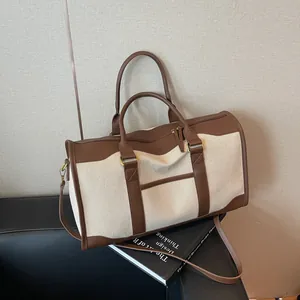 Large canvas travel tote bag with brown leather trim and adjustable shoulder strap