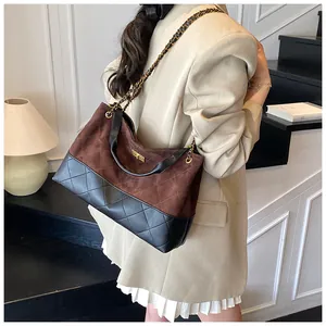 Détail du sac seau bicolore avec motifs matelassés et bandoulière chaîne dorée